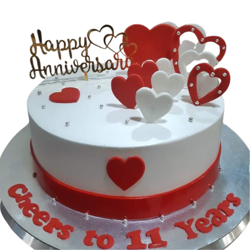 11 years anniversary cake with red and white hearts, topper, and Cheers to 11 Years message.