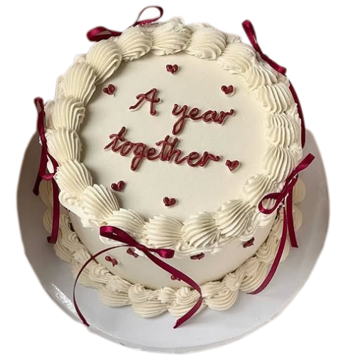 1st anniversary cake with white cream swirls, red ribbons, and A Year Together message.