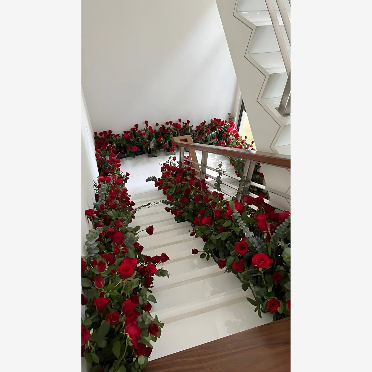 A grand staircase adorned with a breathtaking display of vibrant red roses, creating a captivating and luxurious ambiance.