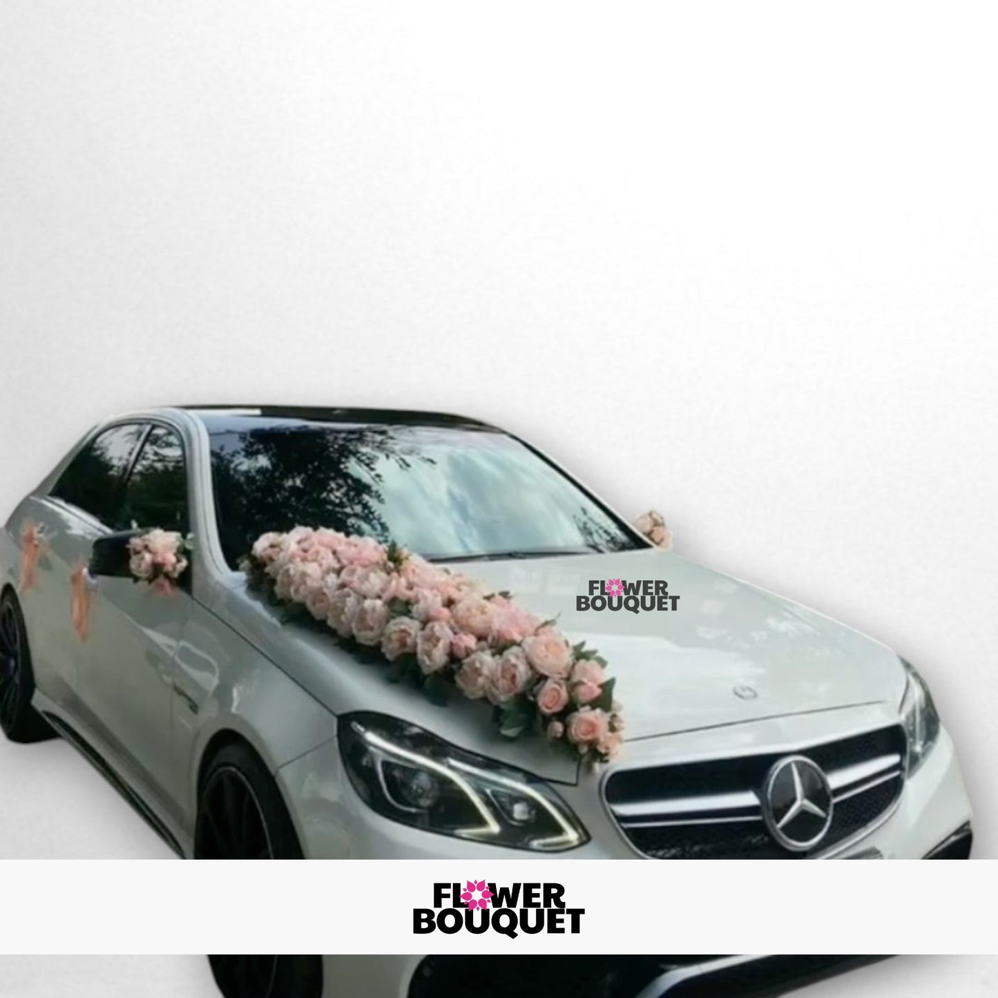 White Mercedes-Benz car decorated with pink flower arrangements on the hood and sides.