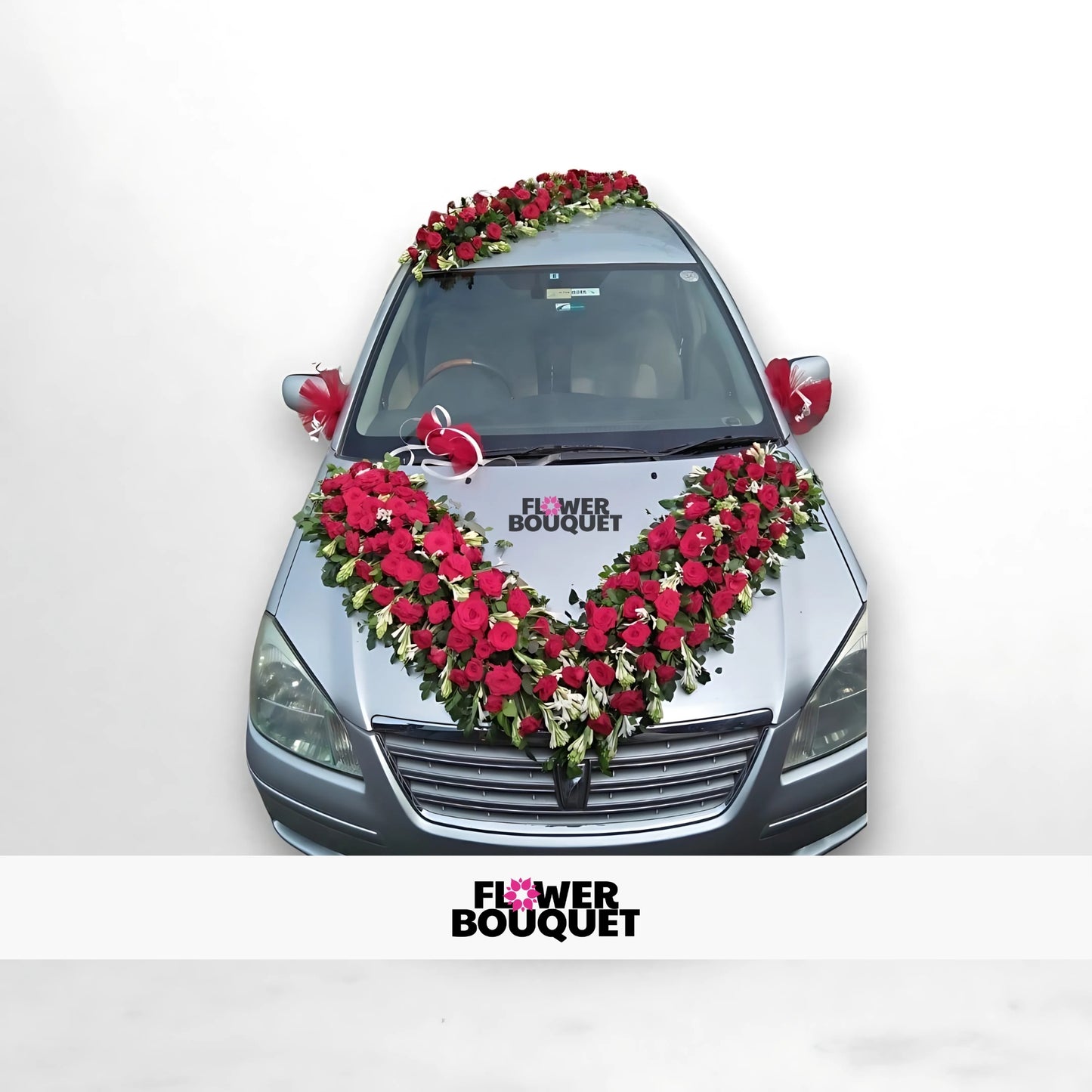 Silver car decorated with red and white flowers in a V-shape on the hood and roof.