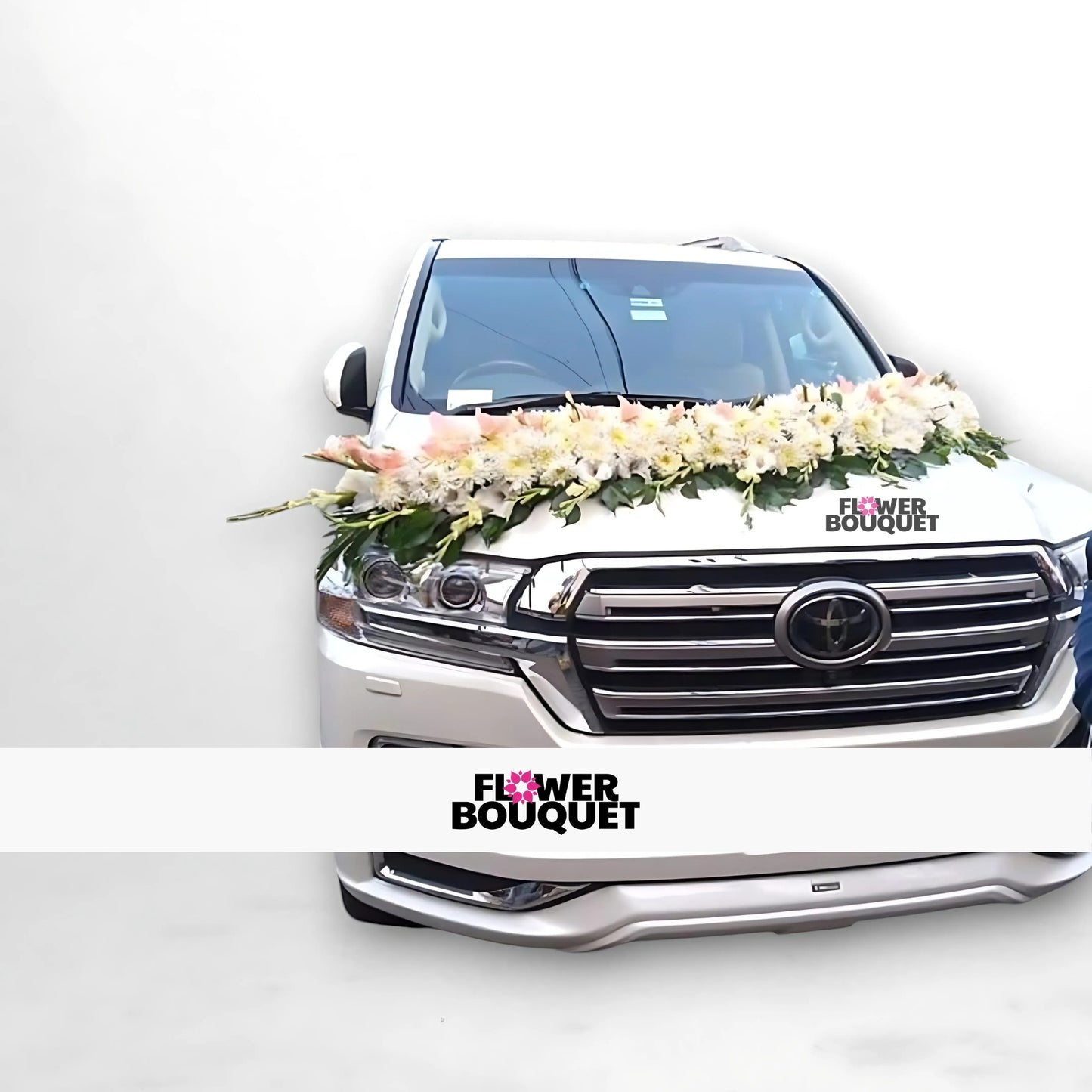 White SUV decorated with white and pink flowers on the hood.