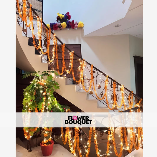 A grand staircase adorned with a captivating display of vibrant floral garlands, twinkling lights, and lush greenery, creating a warm and inviting ambiance.