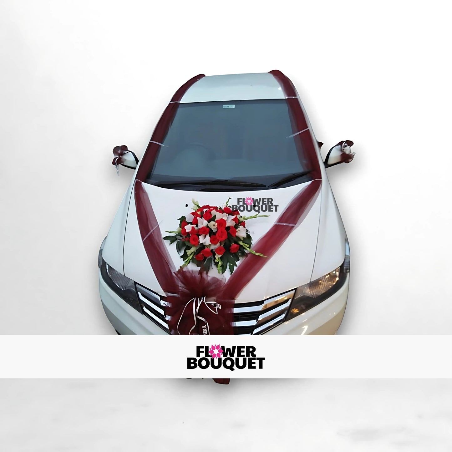 White car decorated with maroon ribbons and a floral arrangement on the hood.