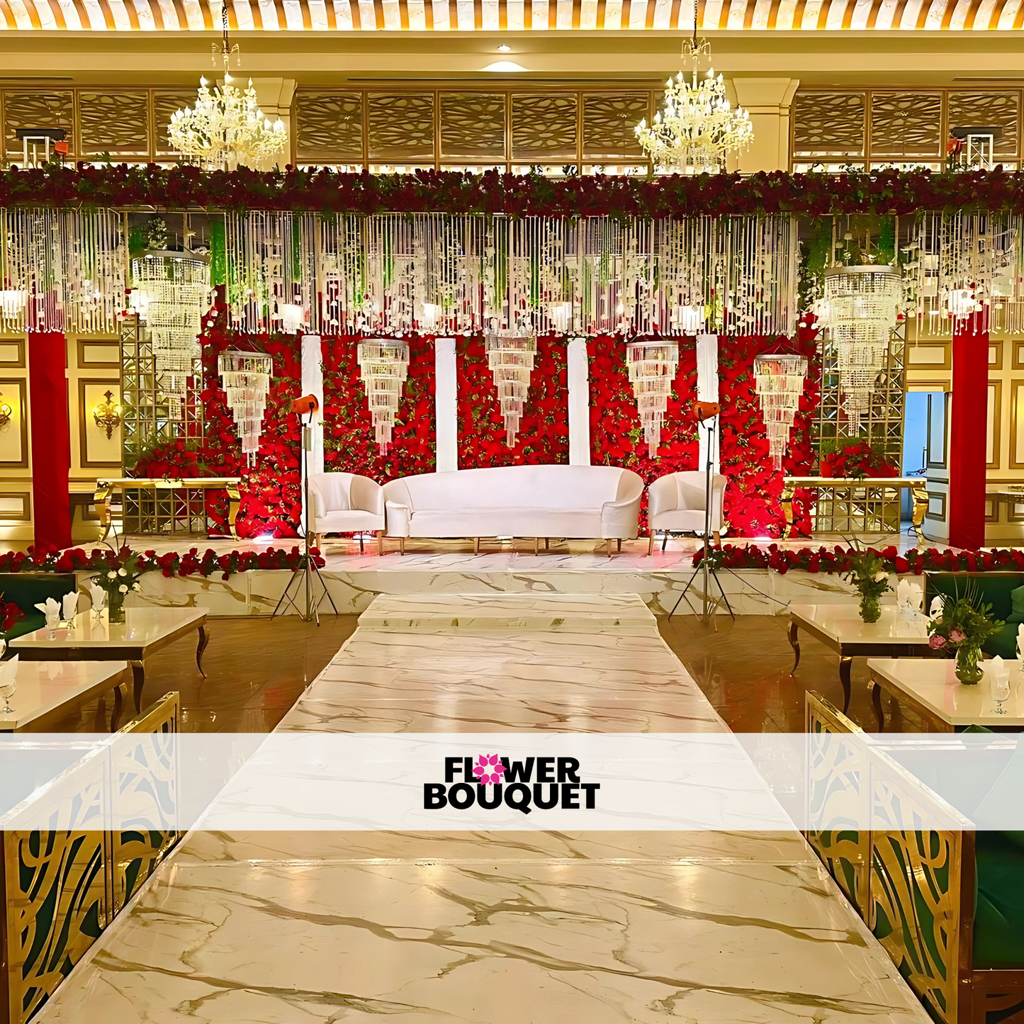 Luxurious Walima stage featuring a red rose floral wall, crystal chandeliers, white tufted sofa, and a marble-textured walkway, perfect for elegant celebrations.