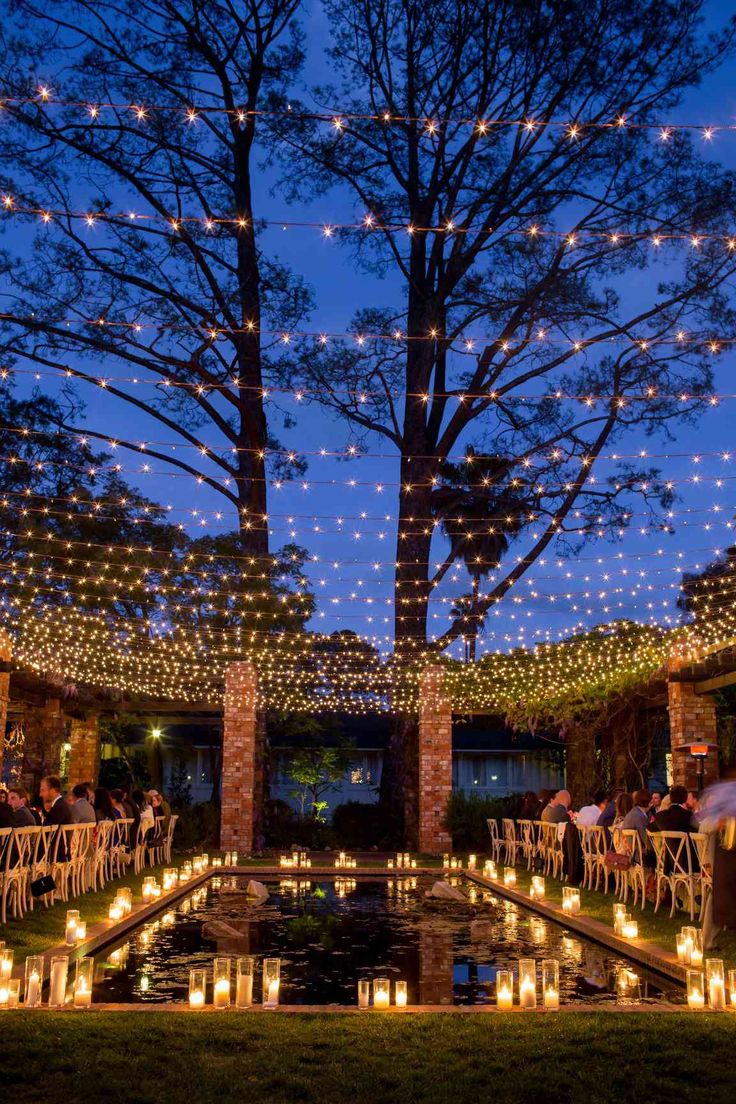 Outdoor string lights draped over trees and a pathway, creating a magical ambiance for a garden or event.