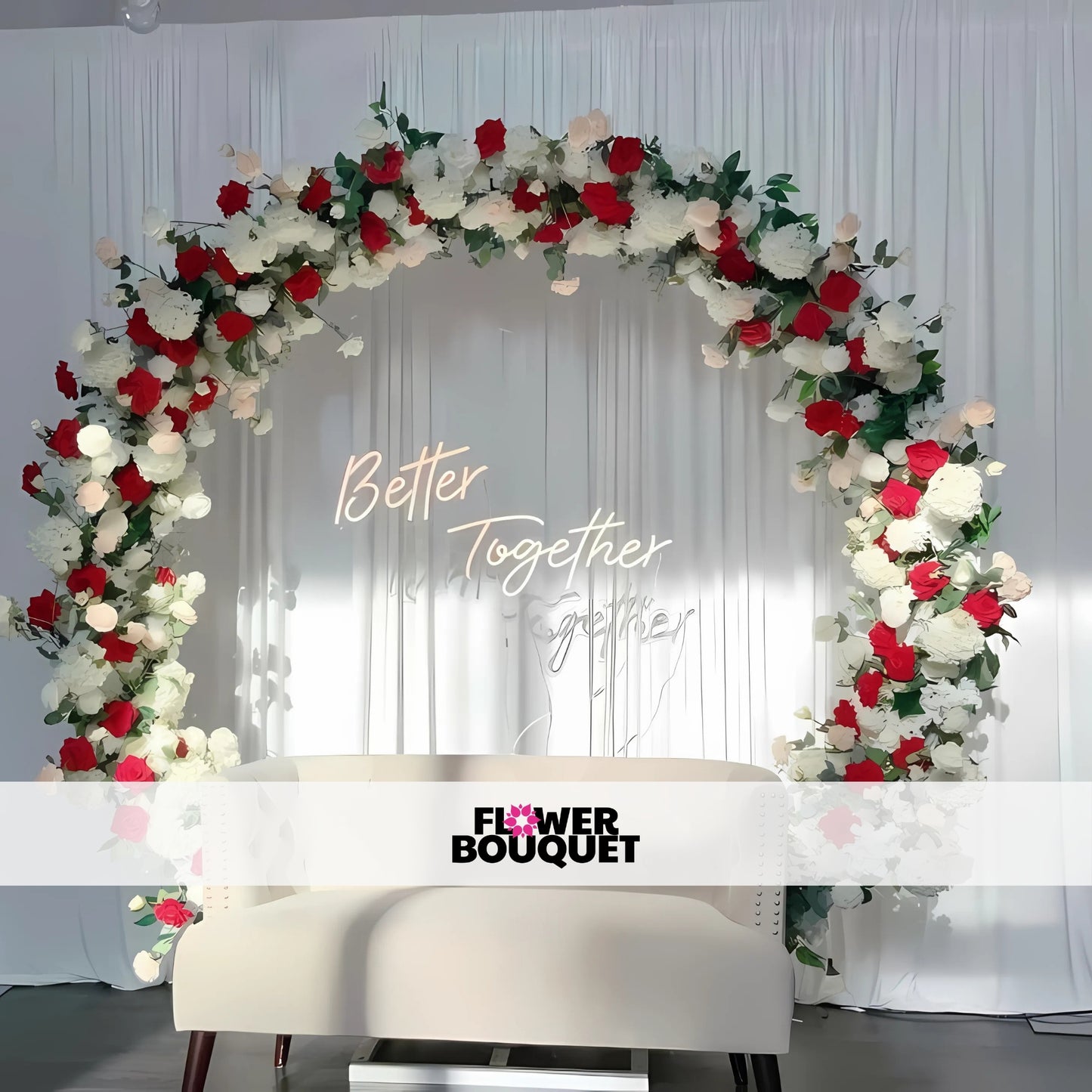 A beautifully decorated wedding arch with white flowers, lush greenery, fairy lights, and a white cushioned bench in front.