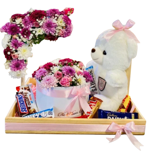 Teddy bear gift hamper with fresh flowers and assorted chocolates in a wooden tray