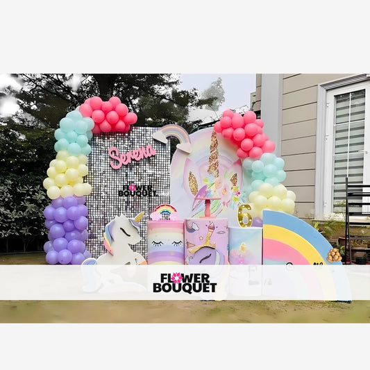 Unicorn birthday party decoration with a large unicorn head, glittery golden ears and horn, pastel-colored balloons, pink cursive name 'Serena,' rainbow arch, and golden number '6,' creating a magical and festive atmosphere.
