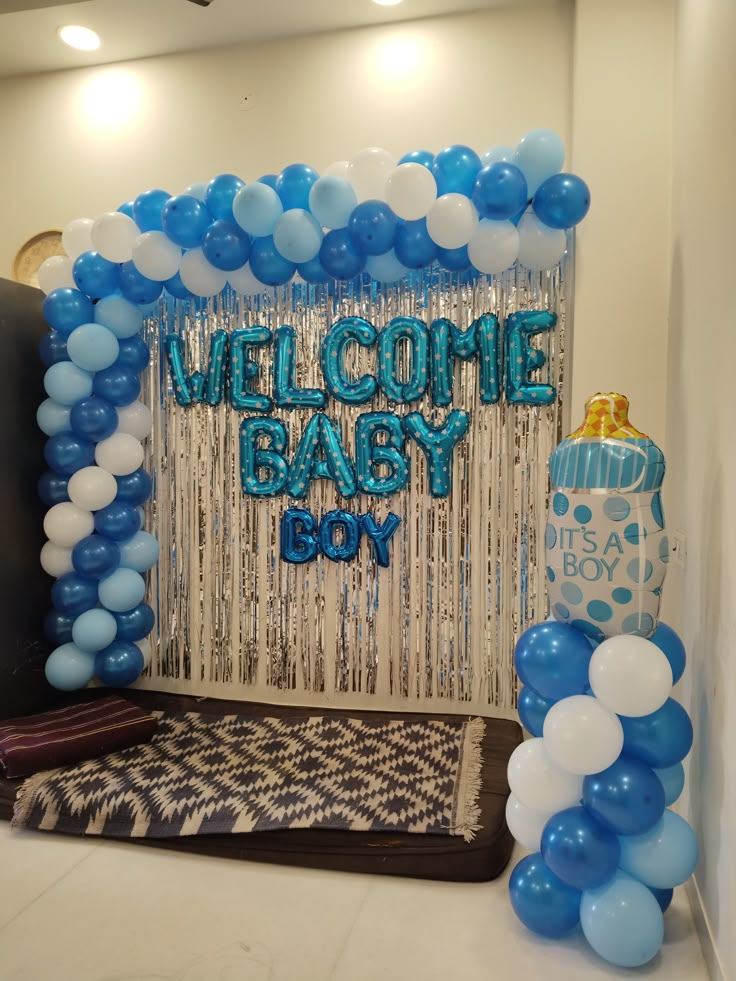 Welcome Baby Boy balloon decoration backdrop with blue and white balloons and baby bottle prop.
