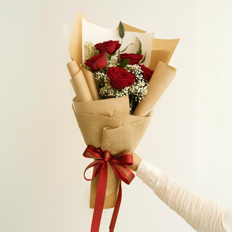 white roses sorry flower bouquet with apology card in it with black wrapping.