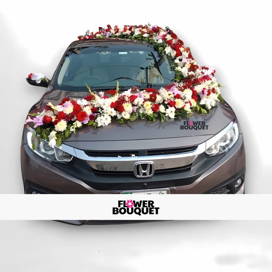 Gray Honda car adorned with colorful flower garland around windshield and hood for weddings.