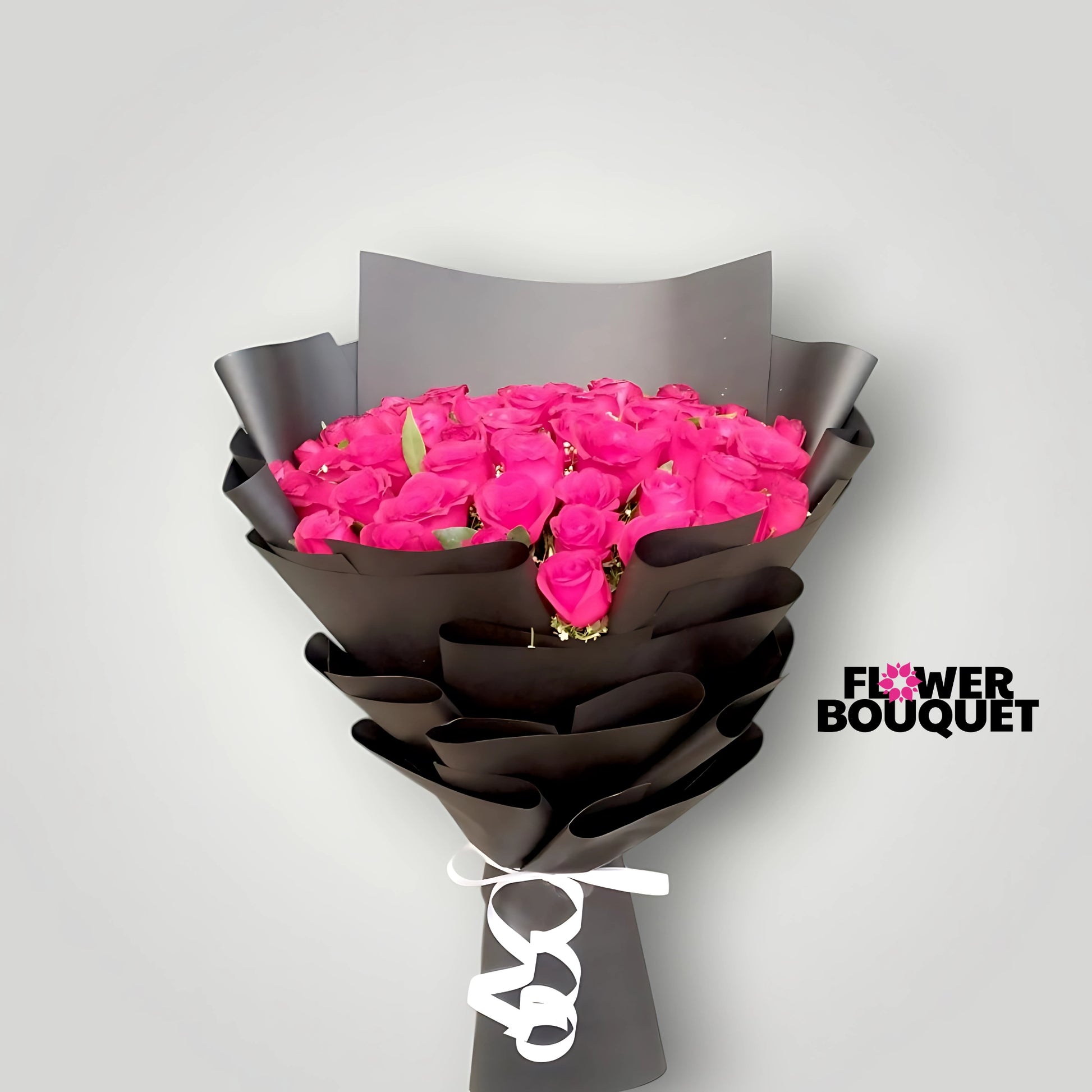 Vibrant pink roses bouquet wrapped in black paper with a white ribbon