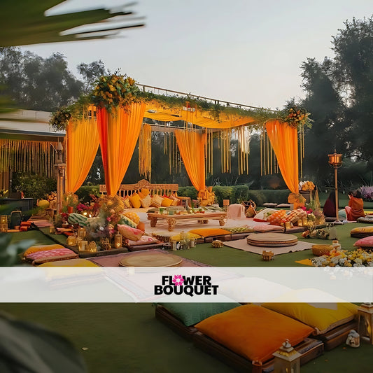 Outdoor Mehndi pavilion with yellow and orange drapes, floral accents, cozy floor seating, and traditional low tables for a grand celebration.