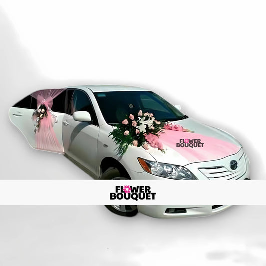 White Toyota sedan decorated with pink and white floral arrangement, pink tulle ribbon, and Flower Bouquet logo for weddings.