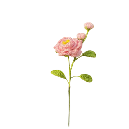 Handmade crochet camellia flower with two pink buds and green leaves on a long stem.