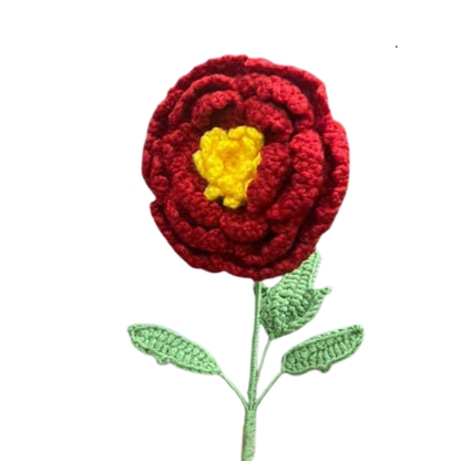 Handmade crochet marigold-inspired flower with red petals, yellow center, and green leaves.