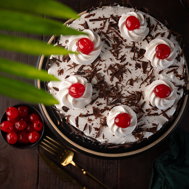 "Kitchen Cuisine Black Forest Cake with whipped cream, cherries, and chocolate shavings, available in Lahore, Karachi, and Islamabad"