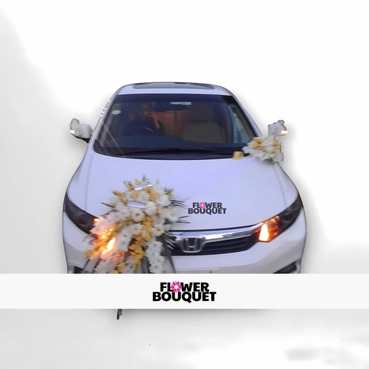 White car decorated with white and yellow flowers on the hood and side mirror.