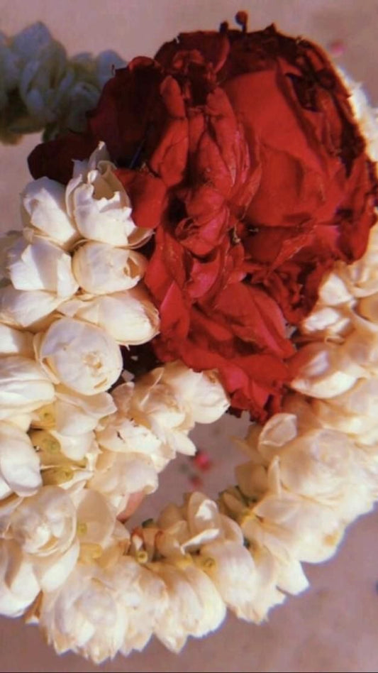 A traditional wedding garland made of red roses and white jasmine flowers, designed for a bride or groom.