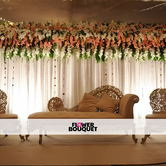 Wedding stage featuring a white and peach floral canopy, vintage carved furniture, and a flowing white backdrop, perfect for elegant celebrations