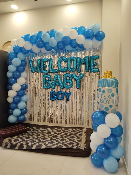 Welcome Baby Boy balloon decoration backdrop with blue and white balloons and baby bottle prop.